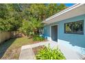 Charming one-story home featuring lush landscaping, a walkway, and a bright blue exterior at 104 Anclote Rd # 104, Tarpon Springs, FL 34689