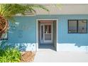 Welcoming front entrance with a light blue exterior and decorative plants around the unit number at 104 Anclote Rd # 104, Tarpon Springs, FL 34689