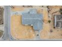 Birds eye view of the home with a grey roof, tan gravel yard, concrete driveway and streets at 1118 Excalibur St, Holiday, FL 34690