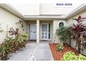 Home entrance with covered porch, landscaping, and concrete walkway at 11266 Kapok Grand Cir, Madeira Beach, FL 33708
