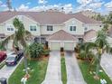 Aerial view of a two-story townhome with mature landscaping and a two-car garage at 11266 Kapok Grand Cir, Madeira Beach, FL 33708