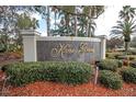 Kapok Grand neighborhood sign surrounded by lush landscaping and mulch at 11266 Kapok Grand Cir, Madeira Beach, FL 33708