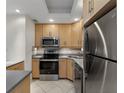 Stainless steel appliances complement the tile backsplash and light wood cabinetry in this kitchen at 1200 N Shore Ne Dr # 102, St Petersburg, FL 33701