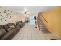 Spacious living room featuring tile flooring, ceiling fan, and a staircase to the upper level at 12709 Raeburn Way, Tampa, FL 33624