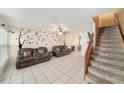 Bright living room boasts neutral tile floors and stairs leading to the upper level at 12709 Raeburn Way, Tampa, FL 33624