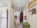 Hallway leads to the living area, featuring a stainless steel refrigerator and neutral decor at 1433 S Belcher Rd # F20, Clearwater, FL 33764