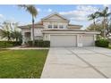 Charming two-story home boasts a spacious three-car garage, tile roof, and well-manicured landscaping with palms at 18014 Forest Retreat Ln, Tampa, FL 33647