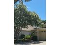 Charming single Gathering home featuring mature landscaping with flowering tree and attached garage at 19432 Haskell Pl, Land O Lakes, FL 34638