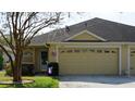 Inviting front exterior showing attached garage, well-manicured lawn, and mature landscaping at 19432 Haskell Pl, Land O Lakes, FL 34638