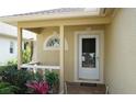 Close up of a quaint front porch, showcasing decorative details and well maintained bushes at 19432 Haskell Pl, Land O Lakes, FL 34638