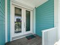 A welcoming entrance with double glass doors framed by white trim, showcasing a tidy coastal style at 30 79Th Ave, Treasure Island, FL 33706