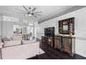 Comfortable living room with dark hardwood floors, a ceiling fan, and a stylish bar area at 30715 Burleigh Dr, Wesley Chapel, FL 33543