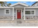 Charming home featuring a red door, stone accents, and a welcoming front porch at 3419 W Empedrado St, Tampa, FL 33629