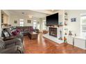 Bright living room featuring a fireplace, hardwood floors, and comfortable leather furniture at 476 Rebstock Blvd, Palm Harbor, FL 34683