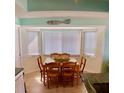 Bright dining area featuring wood table and chairs near a large window at 712 Beach Trl # C, Indian Rocks Beach, FL 33785