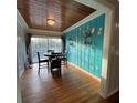 Dining room with wood floors, a unique accent wall, and a sliding glass door to the outside at 1564 S Michigan Ave, Clearwater, FL 33756