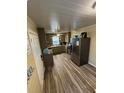 Well-lit kitchen with wood-look tile flooring, stainless steel appliances, and dark cabinets at 1564 S Michigan Ave, Clearwater, FL 33756