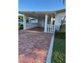 Charming home carport with a brick driveway and detailed white columns, a welcoming entrance at 16103 4Th E St, Redington Beach, FL 33708