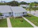 Aerial view of townhomes, showcasing well-manicured lawns, mature landscaping, and community streets at 211 Somerset Cirle N, Dunedin, FL 34698