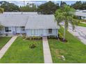 Aerial view of townhomes, showcasing manicured lawns, sidewalks, mature landscaping, and community streets at 211 Somerset Cirle N, Dunedin, FL 34698