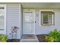 Close-up of the inviting front entrance featuring a welcome mat and charming decor at 211 Somerset Cirle N, Dunedin, FL 34698