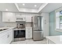 Bright kitchen featuring stainless steel appliances, modern white cabinetry, and white countertops at 211 Somerset Cirle N, Dunedin, FL 34698