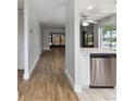 Open-concept living area with modern flooring and a view into the updated kitchen at 211 Somerset Cirle N, Dunedin, FL 34698