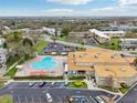 Aerial view of the condo community highlighting the swimming pool, parking area, and lush surroundings at 2400 Franciscan Dr # 34, Clearwater, FL 33763