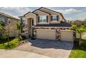 Beautiful two-story home showcasing a three-car garage and manicured landscaping at 3150 Marine Grass Dr, Wimauma, FL 33598