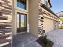 Inviting front entrance with decorative stone accents and a cozy, welcoming ambiance at 3150 Marine Grass Dr, Wimauma, FL 33598