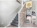 Hallway featuring a staircase with a wood accent wall and tile flooring at 33846 Floating Heart Ct, Wesley Chapel, FL 33545