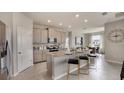 Bright kitchen with gray cabinets, granite countertops, stainless steel appliances, and a dining area at 3420 Hazel Hollow Way, Plant City, FL 33565