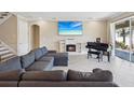 Cozy living room with a fireplace, piano, and a large sectional sofa for comfortable lounging at 3667 Arbor Chase Dr, Palm Harbor, FL 34683