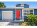 Blue home with red door, white trim, manicured hedges, and stylish tiled driveway to the garage at 3727 38Th N St, St Petersburg, FL 33713