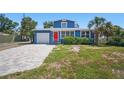 Charming home with a red door, a well-kept lawn, and a paved driveway leading to the garage at 3727 38Th N St, St Petersburg, FL 33713