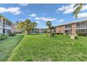 Exterior shot showing a wide green lawn and several condo buildings with screened in lanais at 3847 35Th S Way # 108, St Petersburg, FL 33711
