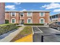 Brick condo building exterior showcasing well-maintained landscaping and reserved parking spaces at 3847 35Th S Way # 108, St Petersburg, FL 33711