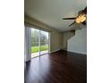 Bright living room featuring hardwood floors, a ceiling fan, and sliding glass doors with a backyard view at 4224 Winding River Way, Land O Lakes, FL 34639