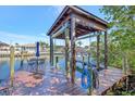 Dock featuring a boat lift, with a waterfront table and chairs, perfect for enjoying the coastal lifestyle at 4707 Troydale Rd, Tampa, FL 33615