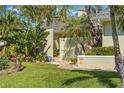 Charming home featuring tropical landscaping and manicured lawn leading to a private front entrance at 725 Monte Cristo Blvd, Tierra Verde, FL 33715