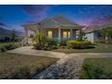Charming single-story home with a welcoming front porch, lush landscaping, and a well-manicured lawn at 729 Winterside Dr, Apollo Beach, FL 33572