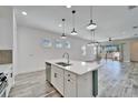 Modern kitchen with pendant lighting, stainless steel appliances, island, and tile flooring at 729 Winterside Dr, Apollo Beach, FL 33572
