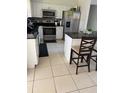 Eat-in kitchen features dark countertops, stainless steel appliances, and tile backsplash at 7413 Sherren Dr, Tampa, FL 33619