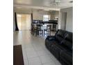 Open living space features tile floors, kitchen access, and natural light from sliding glass doors at 7413 Sherren Dr, Tampa, FL 33619