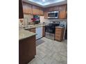 Well-lit kitchen boasts stainless steel appliances, granite counters, and tile flooring at 852 Creekway Ct, Brandon, FL 33511