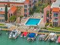 Aerial view of condos with a swimming pool, boat docks, and waterfront access at 8901 Blind Pass Rd # 224, St Pete Beach, FL 33706