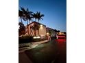 Nighttime view of a gated entrance to a condo complex with palm trees and security at 8901 Blind Pass Rd # 224, St Pete Beach, FL 33706