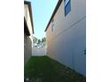 Narrow side yard featuring white fence and green grass at 11201 Hudson Hills Ln, Riverview, FL 33579