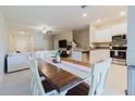Open concept dining area with white chairs and wooden table; connects to the kitchen and living room at 11903 Castine St, New Port Richey, FL 34654