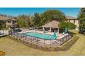 Community pool with seating and covered structure, surrounded by green lawns at 11903 Castine St, New Port Richey, FL 34654